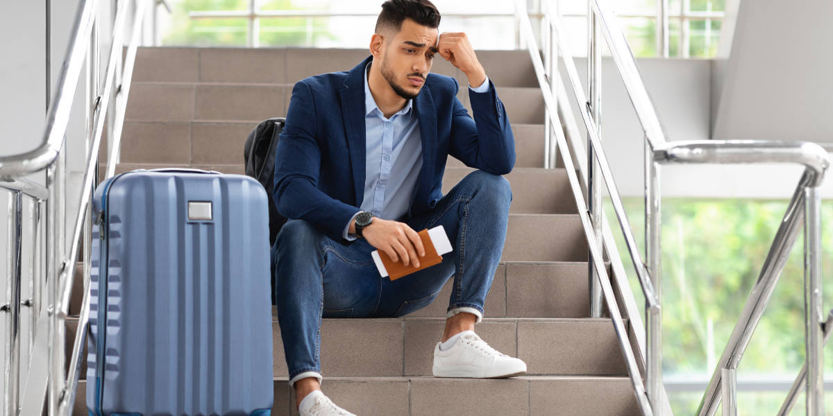 Man sat in an airport anxious about going on holiday